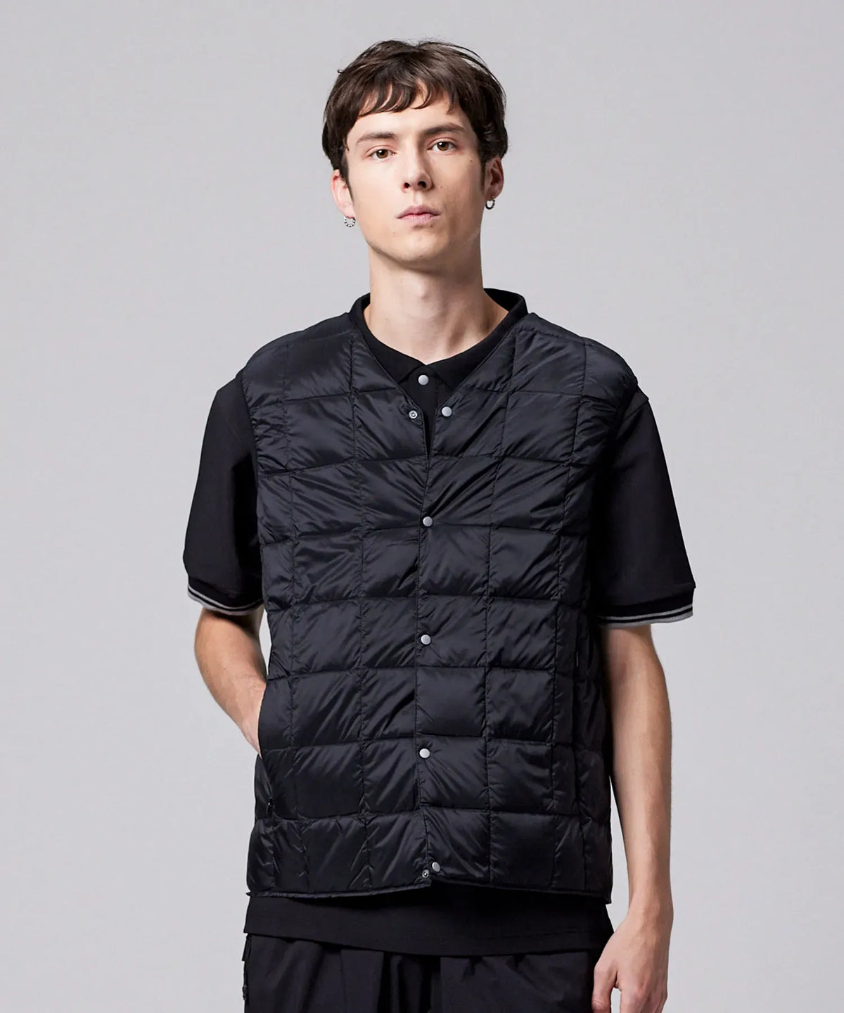 Model layering the Taion V-Neck down vest in black over a shirt