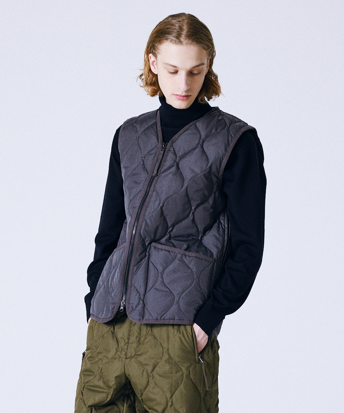 Model wearing the Taion Military V-Neck W-Zip down vest in dark charcoal