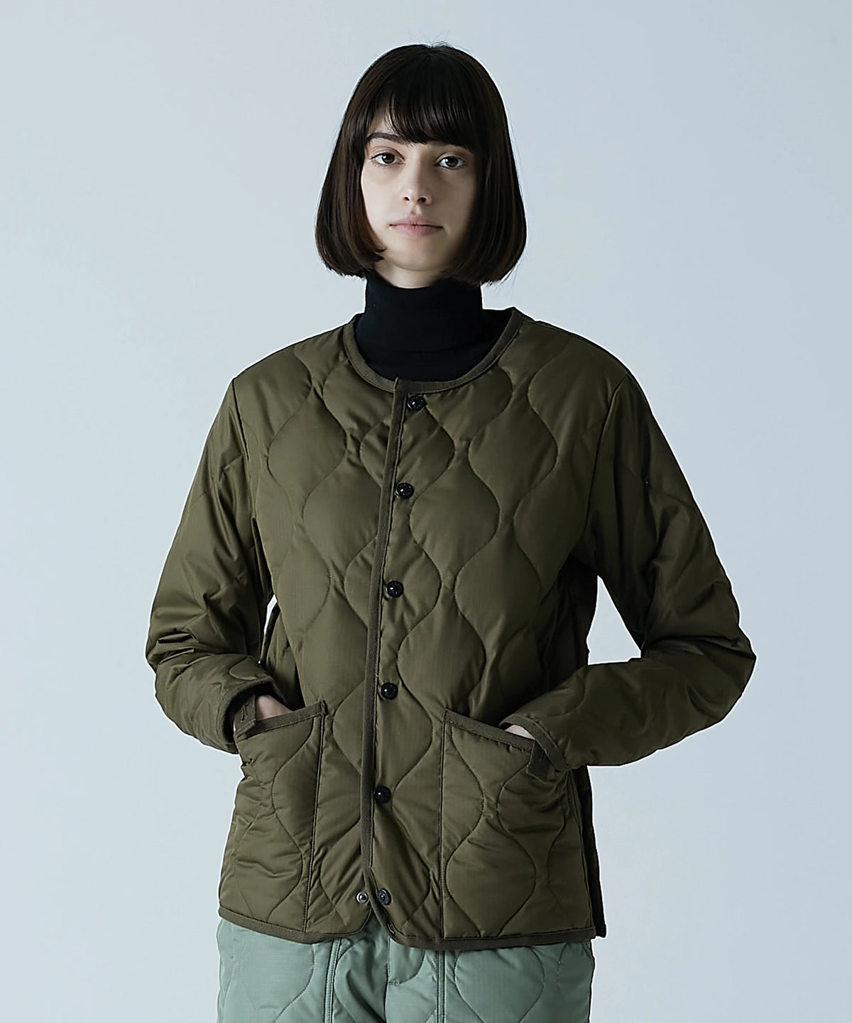Model wearing the Taion Crew Neck Button Down jacket in dark olive
